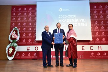 First image shows a formal auditorium with red and white decorations Turkish flags flower arrangements and a banner reading OSTİM a man in a suit stands at a podium speaking to an audience of seated attendees including some taking photos. Second image depicts a large group photo of diverse individuals in formal attire including suits traditional robes and uniforms standing in front of a red backdrop with the text 2025-2026 Akademik Yılı Açılış Töreni and the OSTİM logo. Third image features three men on stage one bald in a suit one with glasses in a suit and one in a red robe holding a blue plaque in front of a screen displaying 2025-2026 Yılı and OSTİM Teknik Üniversitesi with flower decorations and hashtag OSTİM. Fourth image shows two men in suits one holding a small model rocket on a stand in front of a brick wall with the OSTİM Teknik Üniversitesi logo and name in red letters plants visible nearby.