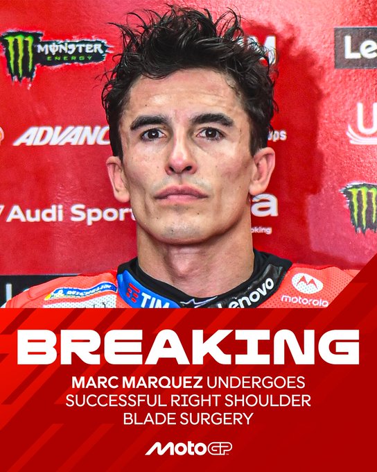 A man with short dark hair wearing a red and blue MotoGP racing suit stands in front of a backdrop featuring Monster Energy, Lenovo, and Audi Sport logos. The text overlay reads BREAKING MARC MARQUEZ UNDERGOES SUCCESSFUL RIGHT SHOULDER BLADE SURGERY in bold white letters on a red background. The MotoGP logo appears at the bottom.