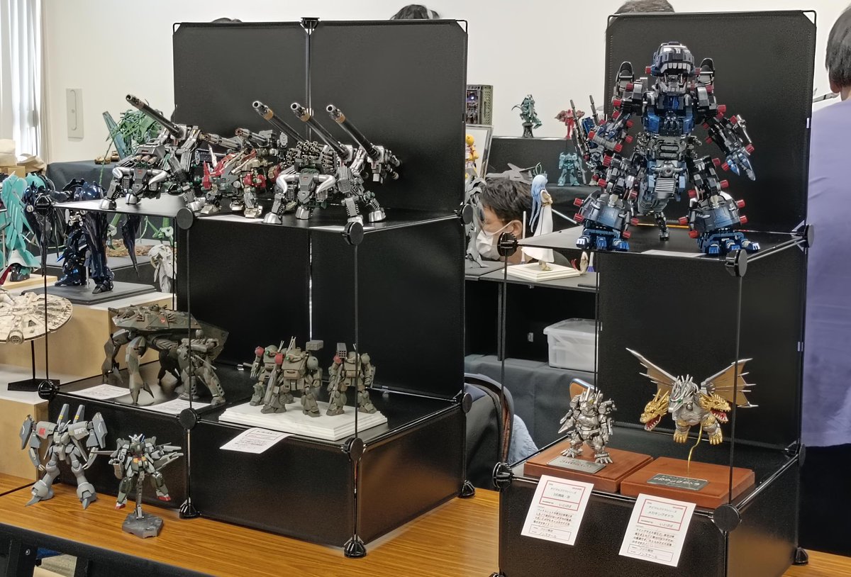 #おかホビ2025 で意外と好評だったのかダイソーの「組み立てパネル」「連結ジョイント」を使った展示棚。1段目は35x17（単位cm）で高さを上げて、2段目3段目に35x35を使ってます。なお2段目は左右から見やすいようにパネルのビニールをカッターで切ってワイヤー枠とし、3段目の背景パネルに（つづく