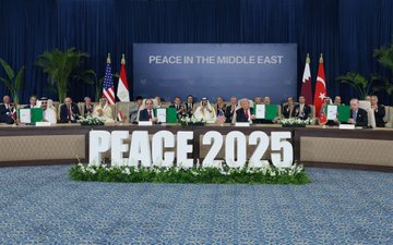 First image shows a conference room with blue curtains, potted plants, and flags from various countries including the United States, Egypt, Qatar, and Turkey behind a long table. Seated officials in formal attire from multiple nations face each other, with large white letters spelling PEACE 2025 in front, surrounded by white flowers on a blue carpet. Second image depicts a woman in a black dress standing beside a seated bald man in a suit signing a document on a table with Turkish flags and a gold trophy nearby, other suited men seated around. Third image features the bald man in a suit holding a green folder with a ribbon, seated with other officials including one in traditional Saudi attire, Turkish flags present, on a wooden table. Fourth image captures a group of men including a blond man in a red tie and the bald man in a suit seated at a curved table with PEACE 2025 signage, flags from Qatar and Turkey, and a banner reading MIDDLE EAST.