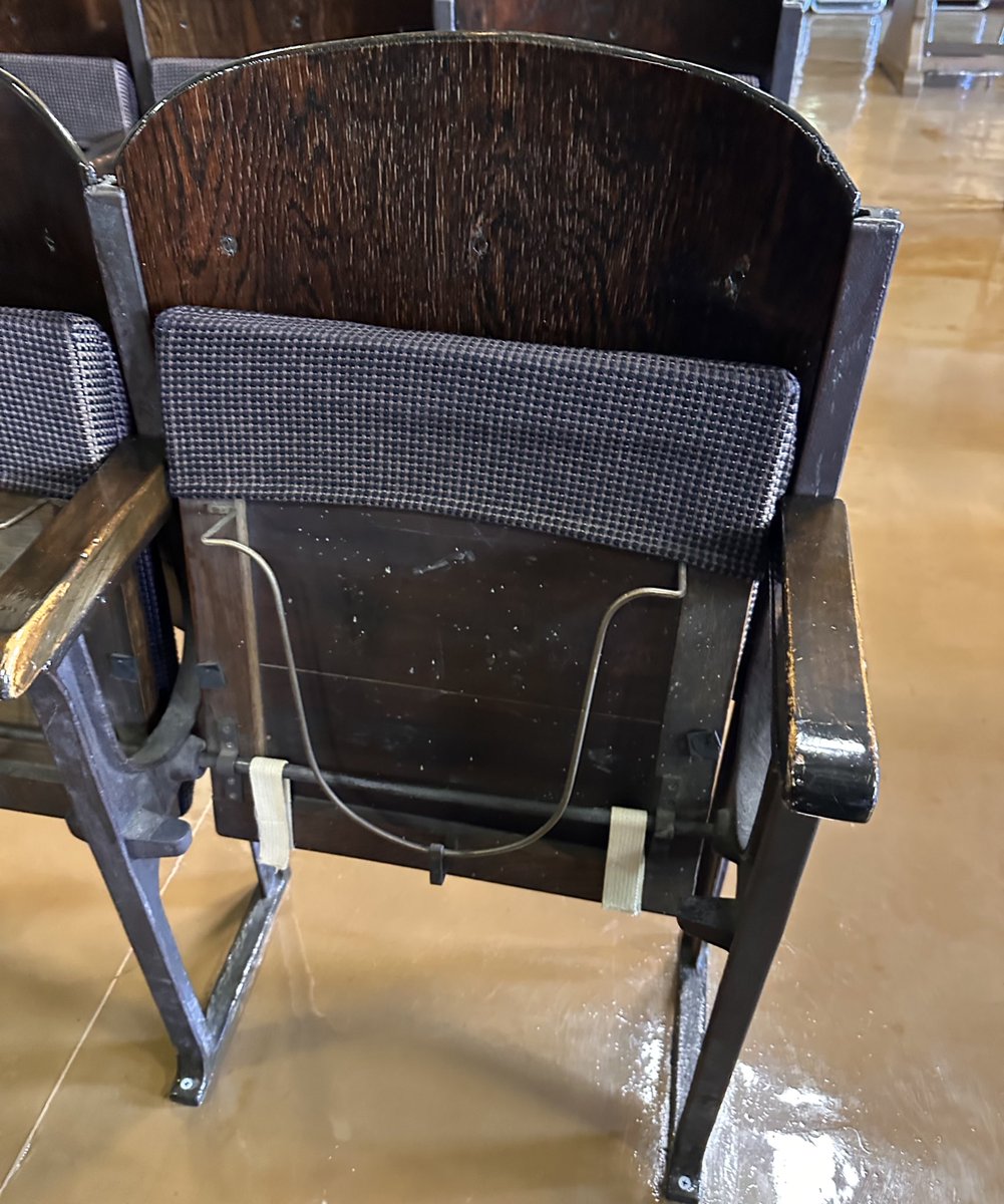 さて皆さんにクイズです。

こちらは天理大学附属天理図書館にある講堂の椅子なのですが、裏にはこのような金具がついております。

この金具は一体、何のために取り付けられたものでしょうか？
（ヒント：この講堂ができたのは昭和5年）

図書館の方曰く、今までで正解できたのはただ1人だけとの事。