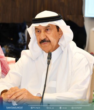 First image displays a large group of men and women in traditional white thobes and abayas standing in a row inside a modern conference room with wooden walls and blue accents posing formally for a group photo with the Federation of Saudi Chambers logo at the bottom. Second image shows a man in white thobe and red and white checkered headscarf with mustache seated at a podium speaking into a microphone during a meeting with a nameplate and logos visible. Third image depicts participants including men in thobes and women in abayas seated around a conference table in a room with a screen displaying the Qatar-Saudi Joint Business Council meeting title in Arabic and flags of both countries with a photographer in the background.