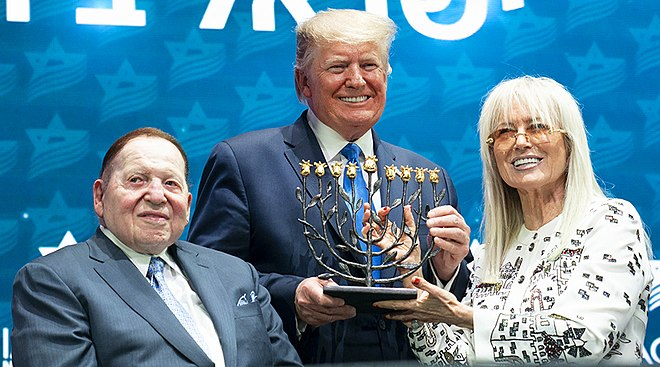 في خطابه يوم أمس أمام الكنيست الإسرائيلي، أشاد الصهيوني ترامب بالصهيونية مريام أدلسون، وطلب منها الوقوف كي تنال نصيبها من التكريم والتصفيق!
ترامب قال في كلمته أمام العالم: 
مريام أدلسون تمتلك 60 مليار دولار، هي أغنى إسرائيلي في العالم، ومن أجل مريم أدلسون، اعترفت بالقدس عاصمة