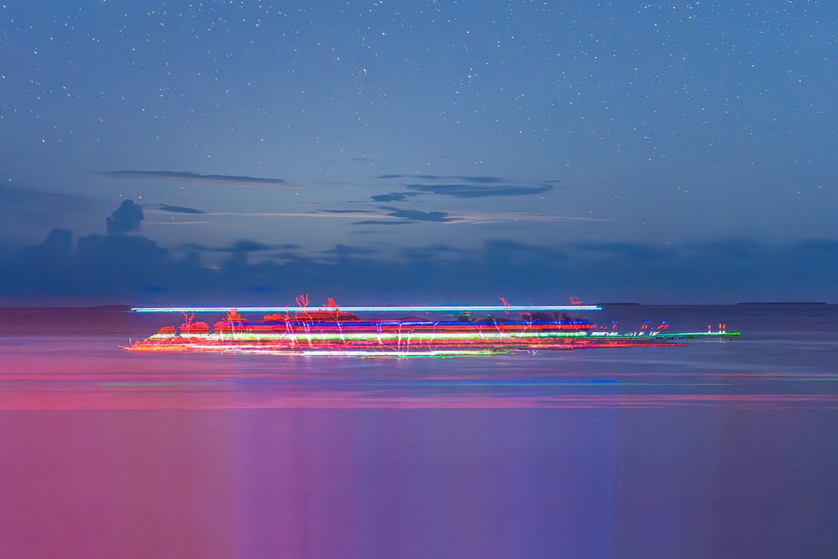 One of my favorites.  The light painting from the boat behind the island perfectly integrated with the projection.  The green line nails the edge of the pier.