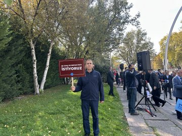 First image shows a man in a cap and jacket holding a black sign reading 3600 EK Gosterge Istiyoruz near a government building with Turkish flag, surrounded by other people and vehicles on a sunny day. Second image depicts several men in suits holding blue and red signs with messages like MEMUR EMEKLI ARTISI YOK SAĞLIK EMEĞİ and ÖĞRETIM EMEĞİ, standing in an open area with trees and flags. Third image features a man in a blue jacket holding a white sign reading EK ZAM VE REFAH PAYI ISTIYORUZ near trees and a speaker setup in a grassy area. Fourth image shows a group including a man in a red vest holding a sign reading ENFLASYONA KARŞI BİRLİK OL and another with MEMUR EMEKLİSİ, near trees and a speaker on grass.
