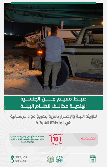 A man in light blue uniform pants and shirt stands with hands in pockets beside a white four-wheel-drive vehicle with red and green markings and Arabic text on the door, parked on sandy terrain at night under a dark sky, with vehicle rear lights illuminated. The scene includes distant hazy mountains or structures and a green rectangular overlay at the bottom with white Arabic text detailing environmental violation enforcement in the Eastern Region, including SFES_KSA logo, date 10, and official seals.