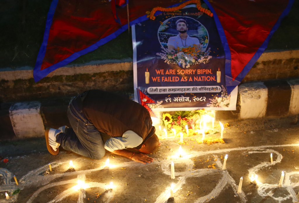 A mourner bows before the photo of Bipin Joshi, a young Nepali student who was held hostage in Gaza and confirmed dead after two years in captivity, during a candlelight vigil in Kathmandu, Nepal, on Wednesday, October 15, 2025.