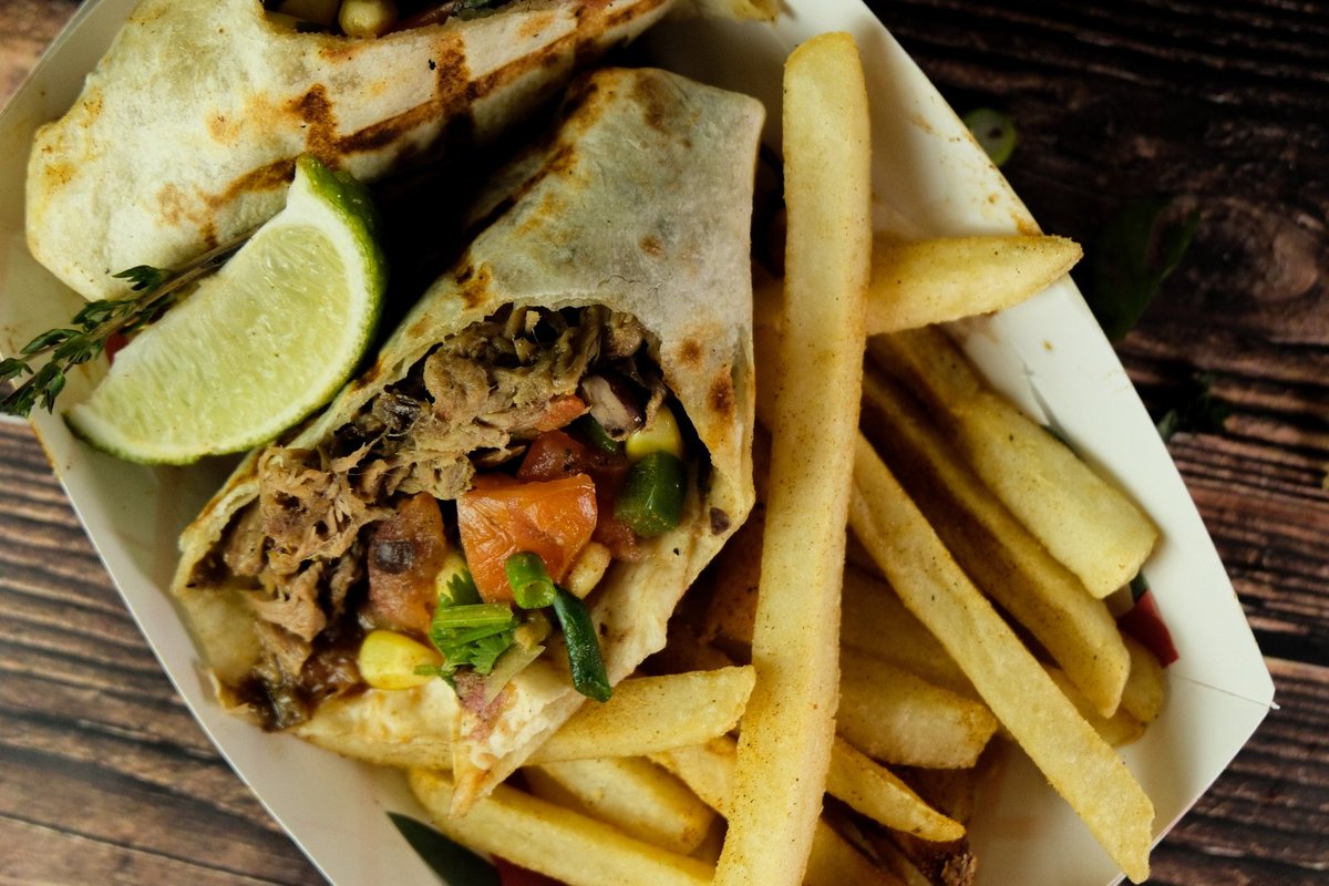 Savor the sensation of our Jerk Pork Wrap with Black Bean-Corn Salsa! 🌯🌽 This Caribbean delight, served with fries, is a fan favorite at Spice The Americas. Discover why today! #FlavorFiesta #SpiceTheAmericas #FanFavorite 🎉