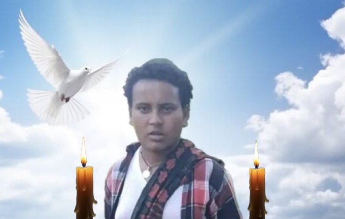 A young woman with short curly hair wearing a plaid shirt and necklace stands outdoors under a blue sky with white clouds a white dove flies above her two lit candles positioned at the bottom foreground