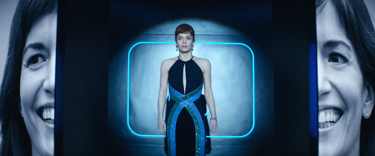 helly's photo splitting to reveal helena (before helly took over) who is standing caged in the lumon logo behind her, wearing a dress that has the colors of the original severance chip. the layers of this are insane