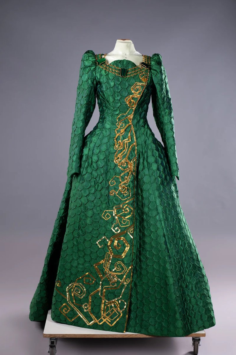 wickedmusicalbr's tweet photo. O figurino de Madame Morrible é uma extensão de sua personalidade manipuladora. 

Tazewell enfatiza que cada escolha de padrão, tecido e corte transmite autoridade e mistério. 

Trajes inspirados em atos circenses reforçam seu poder performático e teatral, refletindo tanto a função de controle sobre outros personagens quanto sua habilidade de criar tensão visual e narrativa.