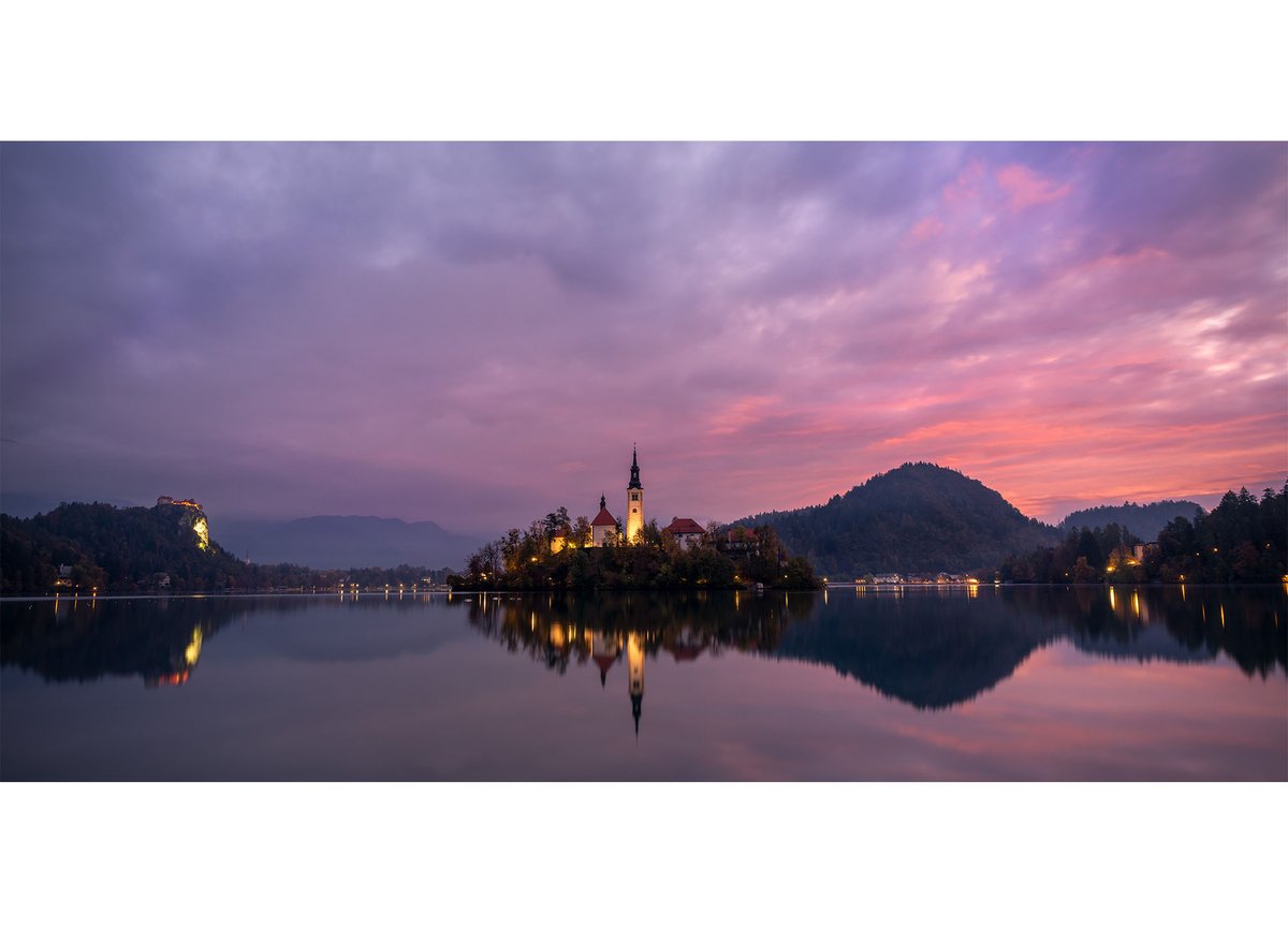 #Sunrise over #LakeBled this morning left stunning colours in a moody sky. The lit buildings also looked amazing against the dramatic landscape. 
#creativephotoadventures