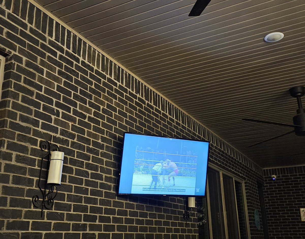 RingFocus's tweet image. I love being able to sit in the hot tub and glancing one way to see my WWF Wrestling Challenge flag in my private gym and then turning slightly to the left and seeing  80s wrestling on my television. If you'd told me I'd be doing this almost 40 years later, I would have laughed.