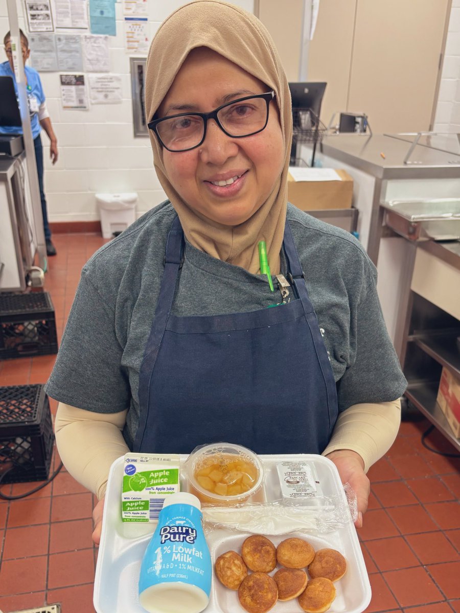 Happy Friday! 🥳☀️ come grab a breakfast tray to start your day off right! Today we are offering warm, sweet Poffitz Pancake Bites with a pear cup, juice, and milk. 🥞  

📸 Pictured: ENGC employee Fowzia ready to serve breakfast!