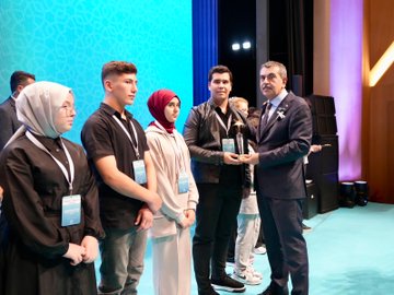 First image shows a man in a suit standing at a podium with a blue backdrop featuring Turkish flags and text in Turkish reading Imam Hatip Okulları Başarılı Örnekler Sergisi Ödül Töreni dated 17 EKİM İSTANBUL. Second image depicts a group of people including women in headscarves and men in suits gathered around a white vintage-style car with ornate designs and a banner reading KASIM 2023 DİN GENEL MÜDÜRLÜĞÜ İMAM HATİP ORTAOKULU in a modern building entrance. Third image captures a large audience of mostly men in suits seated in an auditorium with wooden architecture, banners, and flowers on stage. Fourth image shows a man in a suit presenting a trophy to young people including boys and girls in casual clothes and headscarves on a blue-curtained stage with microphones and awards.