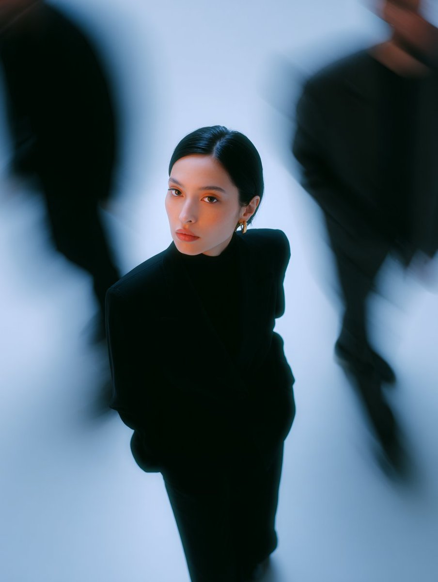 high angle shot form above, portrait of a woman stand in a black outfit, surrounded by long exposure blur people. fashion editorial photography with a minimal style with neutral gray and blue colors --p 4ljrhi9