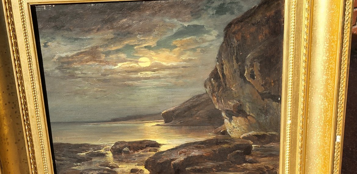 AzmaniP's tweet image. Sujet : Une scène côtière au crépuscule ou au clair de lune. On distingue la mer calme, des rochers au premier plan, une falaise sur la droite, et un ciel nuageux traversé par la lumière du soleil couchant ou de la lune.