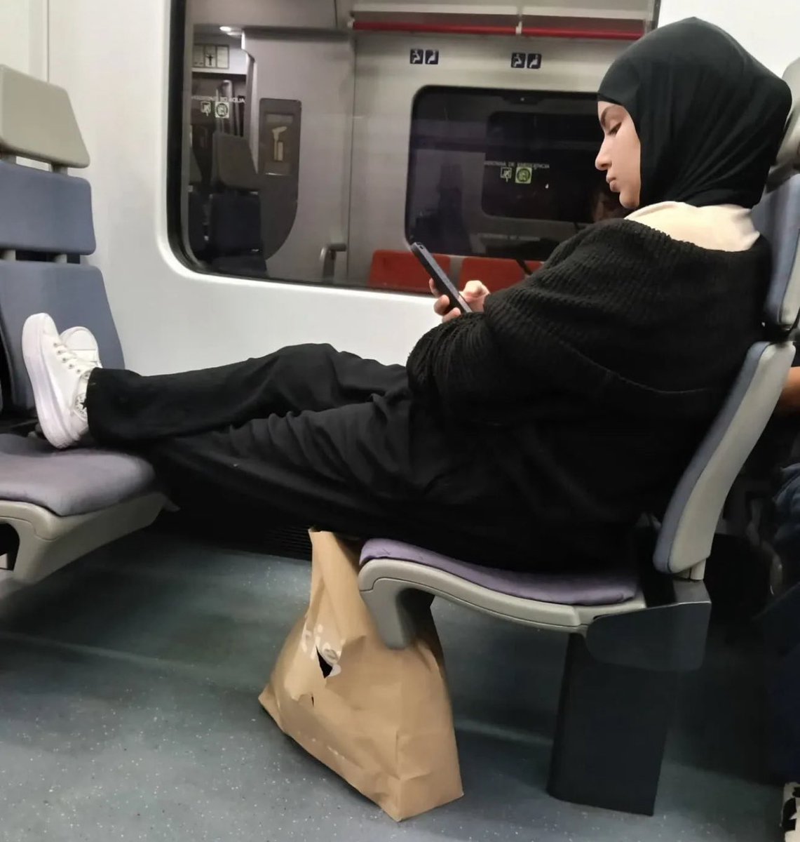 Esto de ir en el transporte público como si fuera el sofá de tu casa es puro incivismo. En este caso, con el problema añadido de que probablemente si le llamas la atención por su falta de educación, te llamarán racista, sin haber hecho comentario alguno sobre su origen o