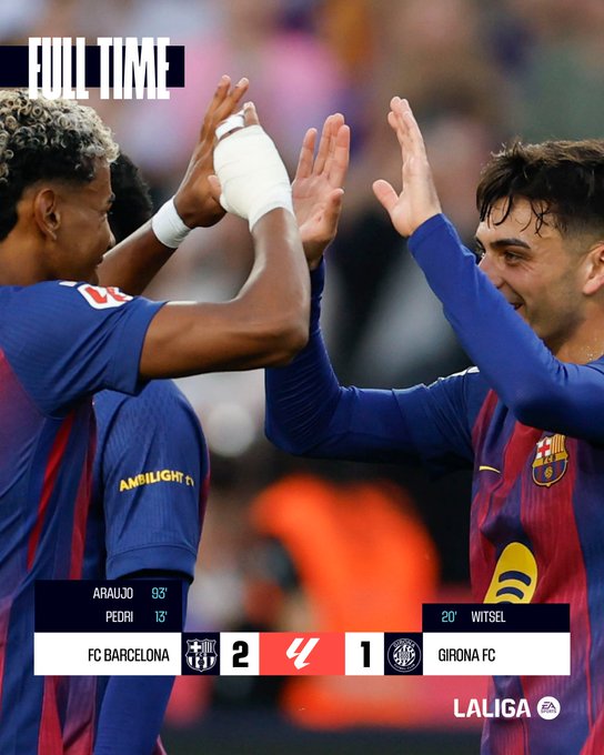 Graphic overlay reads Full Time with FC Barcelona versus Girona FC score of 2-1 in La Liga. Two male soccer players in FC Barcelona blue and red striped jerseys celebrate victory, one with curly hair raising bandaged hand, the other with short hair smiling and gesturing. Stadium crowd visible in blurred background. Scoreboard shows AA 0-3 PED 1-5 2 vs 1 Girona FC.
