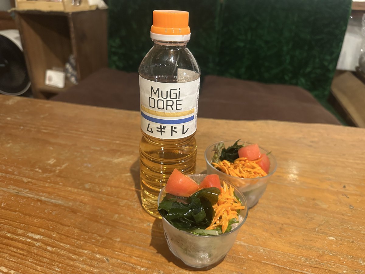 _MuGicafe's tweet image. MuGicafeやムギノワで大好評のドレッシングの販売です☆2本のラインは、MuGicafeのイメージカラーの生成り色と、ムギノワの旗の色でもある青色で表現しております。販売価格は500gで500円です。お家でむぎのドレッシング「ムギドレ」で、たくさんのお野菜召し上がり下さい♪
