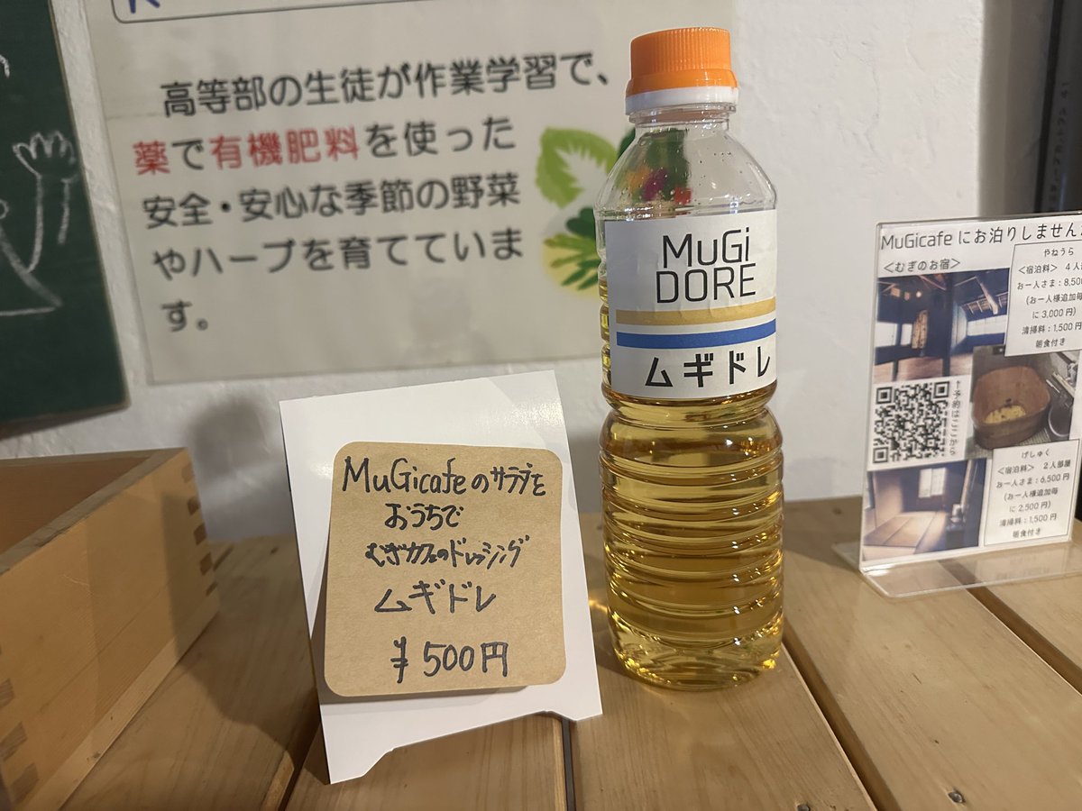 _MuGicafe's tweet image. MuGicafeやムギノワで大好評のドレッシングの販売です☆2本のラインは、MuGicafeのイメージカラーの生成り色と、ムギノワの旗の色でもある青色で表現しております。販売価格は500gで500円です。お家でむぎのドレッシング「ムギドレ」で、たくさんのお野菜召し上がり下さい♪