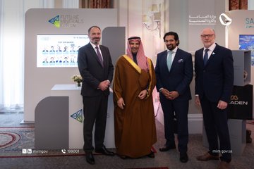 First image shows a man in traditional Saudi attire including red and white checkered headscarf and robe standing at a podium with microphone and papers, speaking in front of a blue backdrop featuring the Maaden logo and text Minerals of the Future Saudi Vision 2030, contact number 199001 visible below. Second image depicts an elegant hall with chandelier and large screen displaying opening remarks by Dr. Khaled Al-Falih, Ministry of Industry and Mineral Resources logo, Maaden logo, and live feed of a woman in abaya speaking, audience seated in formal wear. Third image captures four men in business suits and traditional attire posing together near a display screen showing Future Forum logos and participant photos, flowers on a table, and Maaden emblem. Fourth image illustrates a luxurious venue with red carpet, ornate ceilings, and multiple display booths including Maaden, showcasing professionals in suits and dresses networking and viewing screens with event branding.