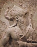 قام الملك الاكدي نارام سين ، حفيد الإمبراطور سرجون الاكدي ، بتأليه نفسه و اعتبار نفسه اله ، فلبس خوذة ذات قرنين لاول مرة في التاريخ ، و قد خالف بذلك المتعارف عليه كملك من لبس العمامة المزينة بالنقوش المماثلة لشبكة صيد الأسماك و الطيور التي لبسها الملوك السومريون قبله 
وربما كان