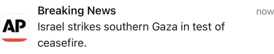 A smartphone screen displays the Associated Press app with a breaking news alert headline reading Breaking News Israel strikes southern Gaza in test of ceasefire, shown against a blurred background.
