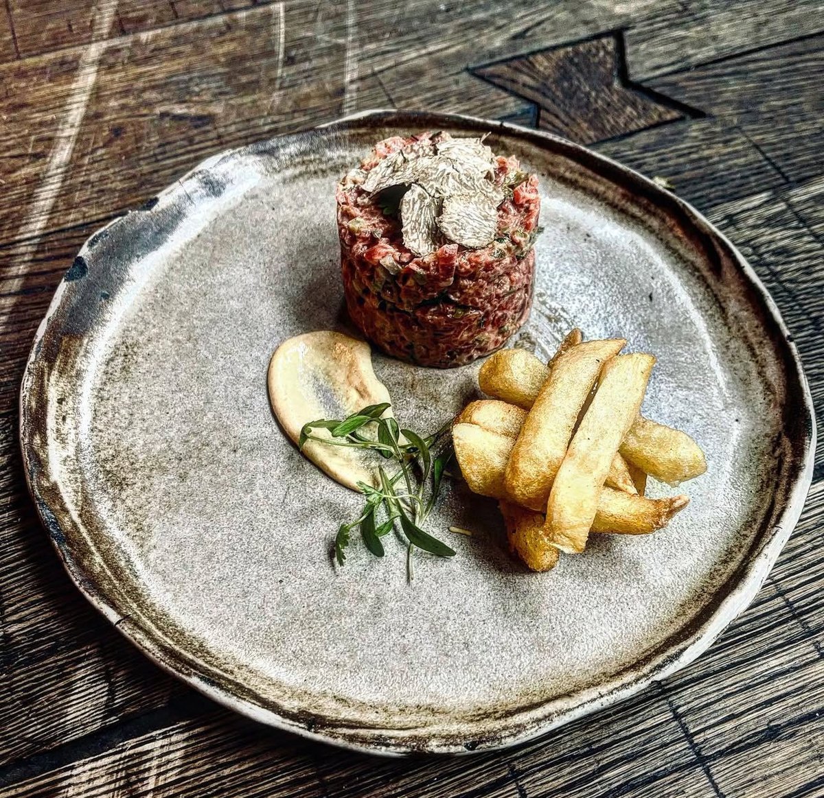 andresmadrigalg's tweet photo. Mi Steak tartar con trufa negra o blanca y patatas fritas,
 
450g de filete de ternera de cadera o de solomillo
15g de trufa negra laminada finamente
20g de chalota
15g de alcaparras lavadas.
20g de pepinillo.
Perejil
2g de Páprika (a gusto).
2 yemas de huevo.
1 pizca de anchoa en aceite de oliva.
Salsa Worcestershire.
2g de jengibre fresco.
8g de mostaza de Dijon.
Pimienta de setchouan molida.
El zumo de medio limón.
2dl de aceite de oliva virgen.
Sal.
 
En un bol al baño Maria frio, montar la yema de huevo con el zumo de limón, al aceite de oliva y la mostaza.
Picar lo más finamente posible la chalota, las alcaparras (éstas bien lavadas), el pepinillo, el perejil, el jengibre, la anchoa y el filete de ternera.
Pasar todo al bol, añadir la salsa Worcestershire, la Páprika, la pimienta de setchouan y la sal. Terminar laminando con trufa negra y acompañar con patatas fritas.

Las patatas fritas
 
3 patatas medianas sin manchas ni golpes.
40cl de aceite de oliva
Agua
Sal
Pimienta blanca molida
 
Lavar bien las patatas y poner a hervir cubriéndolas con agua fría, con piel, durante 12 minutos, y sal. Una vez hervidas, pelarlas y cortarlas en gagos iguales. Pocharlas a 160C durante 8 minutos. Después freír las patatas a 180C. Cuando estén fritas escurrirlas y pasar a papel absorbente por encima, y salpimentar. 
#sedcuriosos