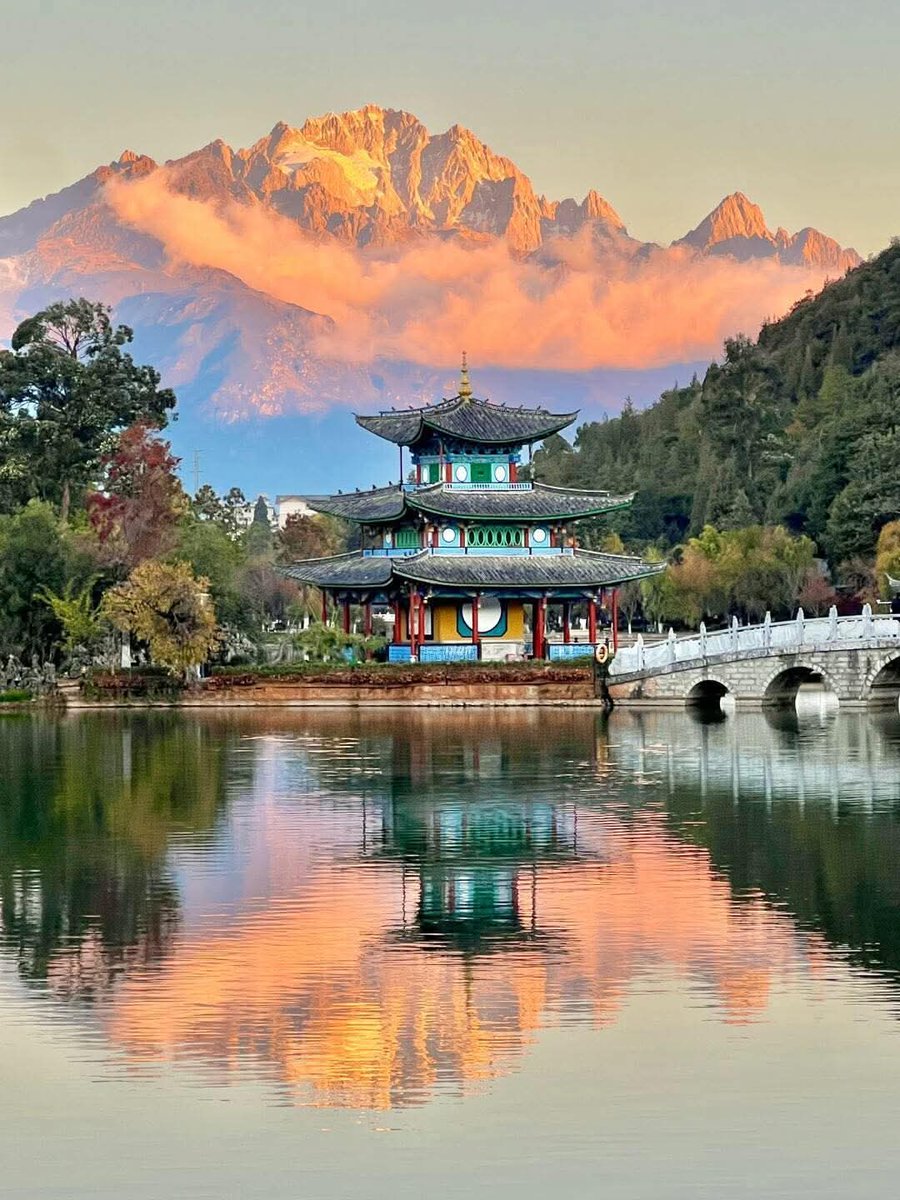 云南丽江黑龙潭公园，日照金山映龙潭。