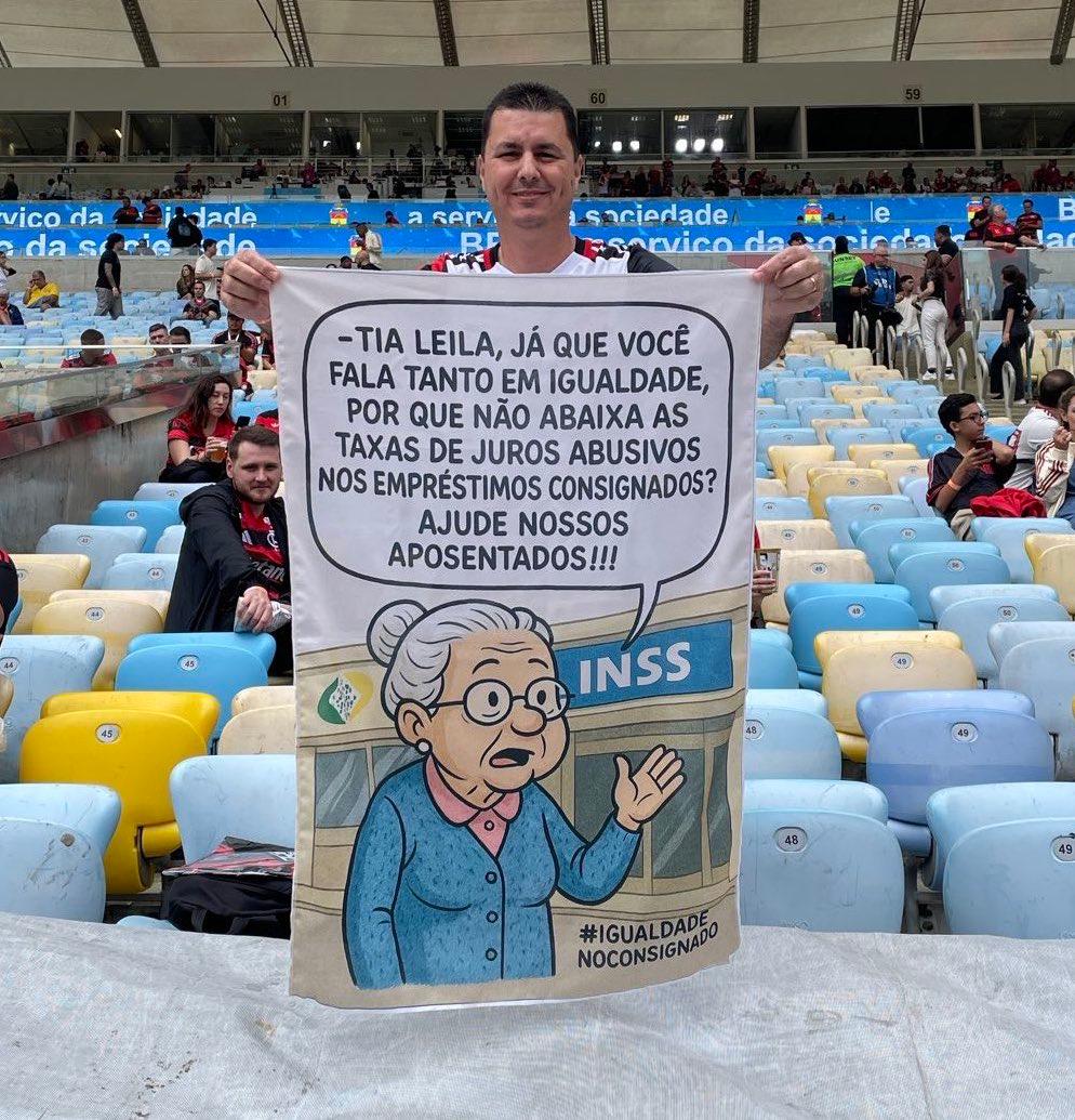 ColunadoFla's tweet photo. 👏 Torcedor do Flamengo leva cartaz ao Maracanã provocando Leila Pereira, presidente do Palmeiras:

🗣️ “Já que você fala tanto em igualdade, por que não abaixa as taxas de juros abusivos nos empréstimos consignados? Ajude nossos aposentados!”

📷 @renanmoura1989 https://t.co/gvAmqn057O