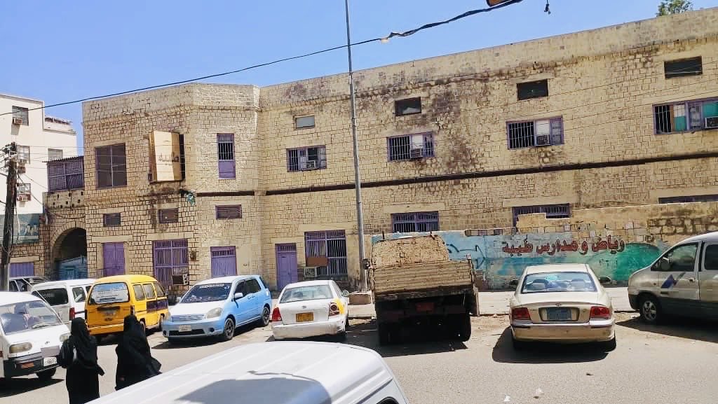 مبنى بمساحة كبيرة في مدينة المعلا كان تابعًا لمعهد الفنون الجميلة في عهد جمهورية اليمن الديمقراطية الشعبية. وبعد الوحدة، قام مسؤول عسكري شمالي ذو نفوذ، من المقربين للرئيس علي عبد الله صالح آنذاك، باقتحامه وبسط السيطرة عليه، مما أدى إلى نشوب نزاع طويل حوله.

وفي وقت لاحق، قام علي