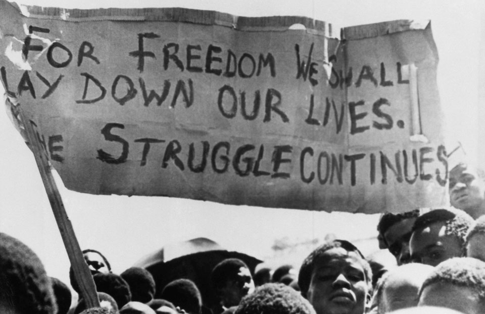 HistorySAZAR's tweet image. A banner is held aloft by students in Johannesburg, South Africa, in the township of Soweto, Oct 18, 1976. Photo | AP