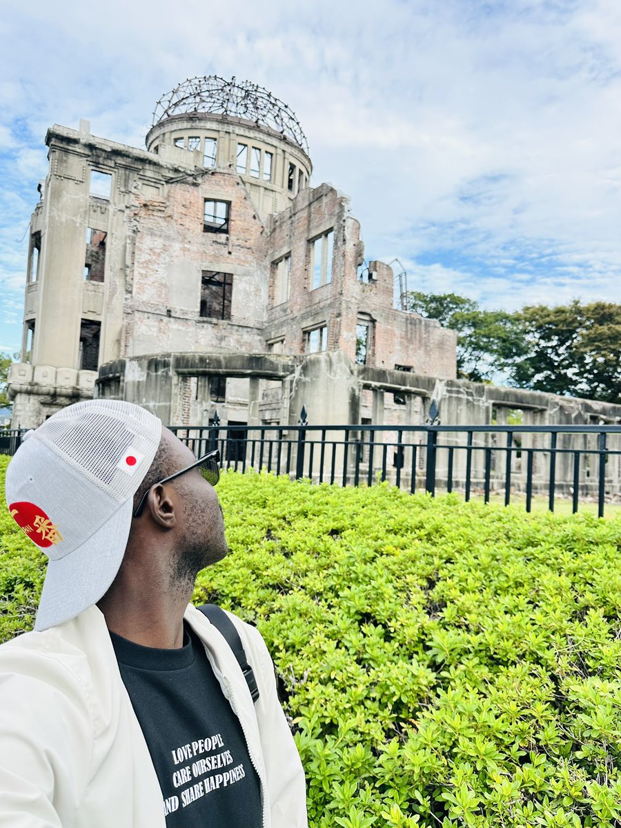 TravelStylist_'s tweet photo. 🇯🇵 Bienvenue à Hiroshima. Une ville dont le nom seul résonne dans les tripes de l’humanité entière.

Ici, plus qu’ailleurs, on ne visite pas un lieu.
On entre dans une histoire.
Une histoire qui ne cherche ni la pitié, ni la revanche, mais la paix.

Hier soir, j’ai parcouru le Musée du Mémorial de la Paix,
et ce matin, j’ai marché lentement à travers le Parc du Mémorial, jusqu’au Dôme de la bombe atomique, ce vestige suspendu entre ruine et renaissance.

Et tout au long du chemin, j’ai compris qu’Hiroshima ne parle pas de la mort. Elle parle de la vie.

La Flamme de la Paix brûle sans jamais s’éteindre.
La Fontaine des Prières coule sans jamais se tarir.

Hiroshima n’est pas une ville détruite.
C’est une ville ressuscitée. Une ville qui a choisi la douceur, là où le monde avait connu la dévastation.

Et c’est sans doute là que réside sa vraie grandeur :
dans sa capacité à transformer la douleur en leçon,
et la leçon en lumière pour l’humanité entière.

En parcourant le Japon avec @Dyscova_ ,  je mesure encore davantage notre responsabilité : celle de raconter le monde sans le trahir. De faire du voyage une rencontre, pas une consommation.

Et je rêve qu’un jour, au Cameroun 🇨🇲,
nos lieux de mémoire et de culture soient honorés comme ici : non comme des blessures à cacher, mais comme des leçons à transmettre.

En quittant le parc, le drapeau japonais flottait dans le vent. Et j’ai compris que la paix n’est pas un mot.
C’est un travail d’âme. Un effort patient.
Une manière d’habiter le monde.

Parce qu’ici, même le silence a une voix. Et cette voix dit doucement :
“Que plus jamais la haine ne parle plus fort que l’amour.”