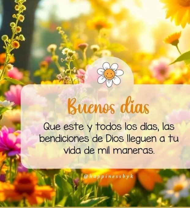 Bright sunny field filled with various colorful flowers including yellow sunflowers, pink and orange blooms, and green stems under a clear blue sky. A white rectangular overlay in the center contains orange text reading Buenos días with a smiling daisy emoji below, followed by pink text stating Que este y todos los días las bendiciones de Dios lleguen a tu vida de mil maneras, and a small watermark at the bottom reading @happinessbyk.