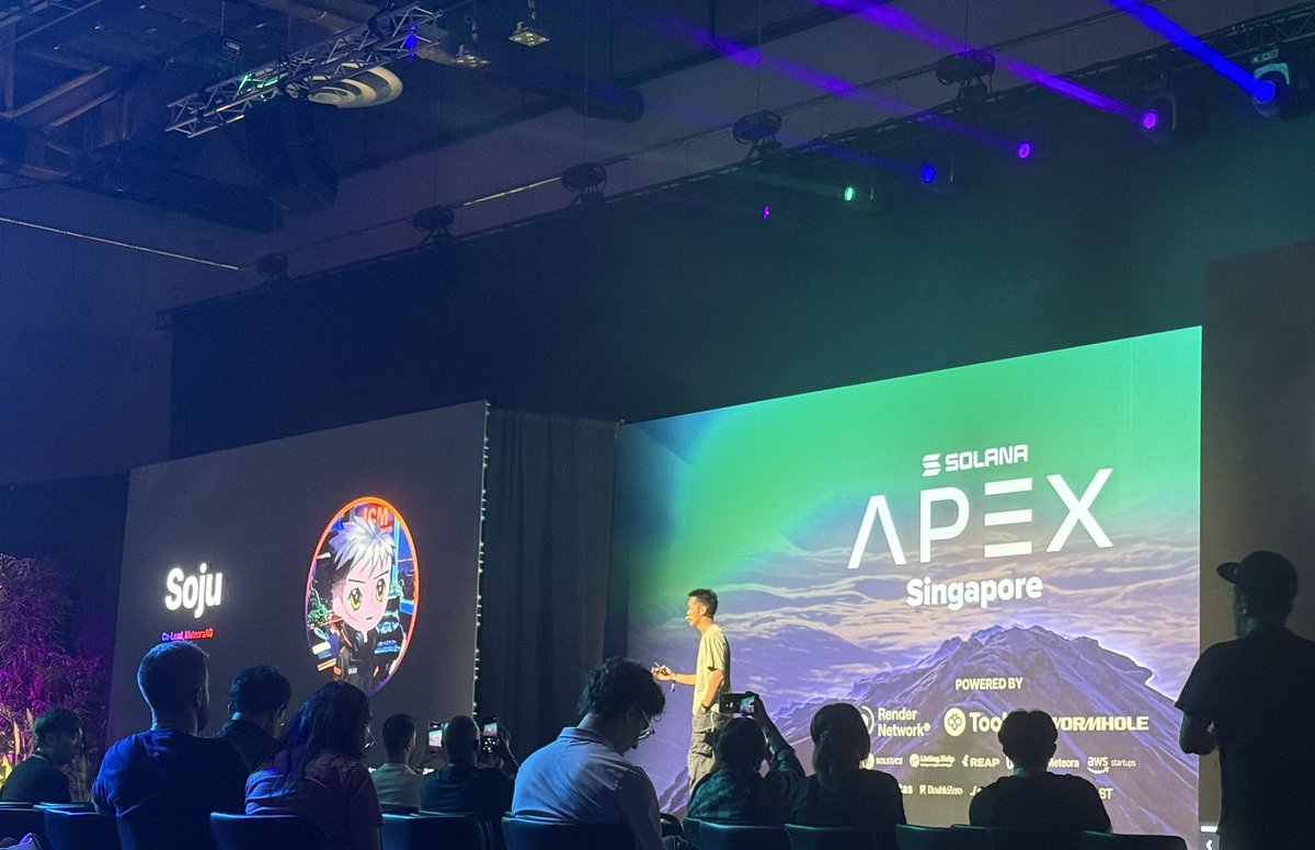 싱가포르에서 열린 Solana Apex 이벤트에서 MeteoraAG를 발표하는 연사, 화면에 Soju 캐릭터