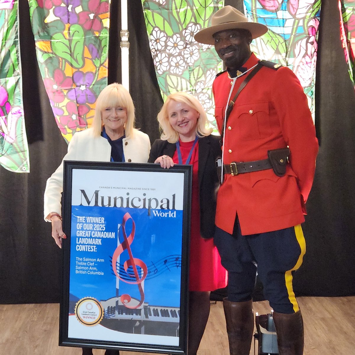 MunicipalWorld's tweet photo. The towering treble clef sculpture in Salmon Arm, B.C., earned first place in Municipal World’s 2025 Great #Canadian #Landmark Contest. Adina Chirita (middle) presented the award to Darlene Kalawasky, at the Communities in Bloom gala, with RCMP Const. Richard Bella. #LoaclGov https://t.co/F2iZxJ7wYY