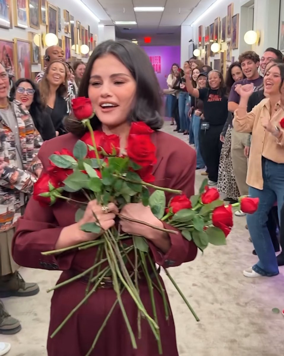 benny blanco handing out flowers and selena gomez receiving them. 🥹