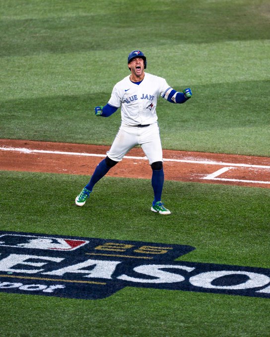 A baseball player wearing a white Toronto Blue Jays uniform with blue sleeves and helmet stands on a green field near the foul line, arms raised in celebration, mouth open shouting, green shoes on feet, with an overlay graphic reading MLB postseason in the foreground.