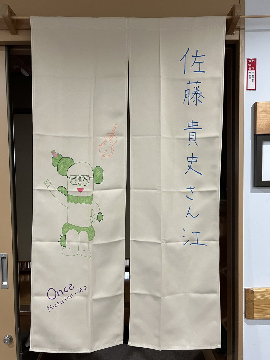 sato_bakashi's tweet photo. とんでもなく嬉しいことが！
暖簾が無くて嘆いてたら、
ONCEのミュージシャンの方々からこんな素敵な暖簾頂いちゃいました！
粋すぎるでしょ...泣
サボがバンクマネージャー仕様になってて可愛い!
本当に本当にありがとうございます！
一生の宝にします！

#ONCE https://t.co/FaOQHCKlEp