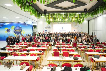 First image shows two side-by-side photos of men in suits speaking at podiums with eTwinning banners Turkish and EU flags and floral decorations in a conference room. Second image depicts a large group of diverse attendees mostly women in professional attire seated at red-covered tables in a spacious venue with blue eTwinning banner hanging plants and a stage. Third image captures an audience raising hands in applause during a presentation with eTwinning logos on screens Turkish flag and colorful banners in a hall with seated participants. Fourth image features a woman presenting at a podium with eTwinning and Together We Shine banners Turkish and EU flags projector screen showing text and attendees seated at tables in a decorated room.