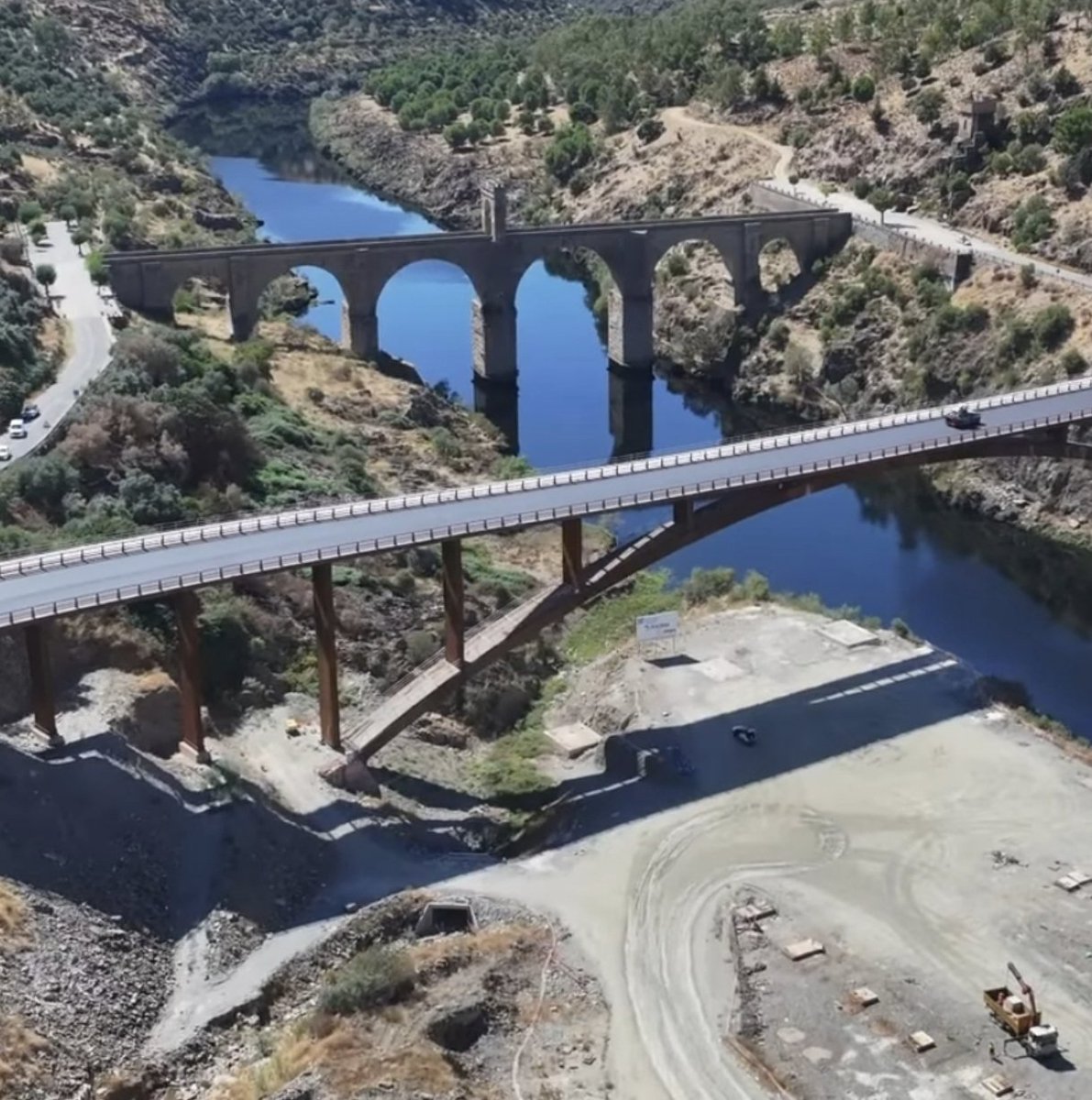 Pasan una carretera por el entorno protegido del mejor puente del Imperio Romano . España, siglo XXI.