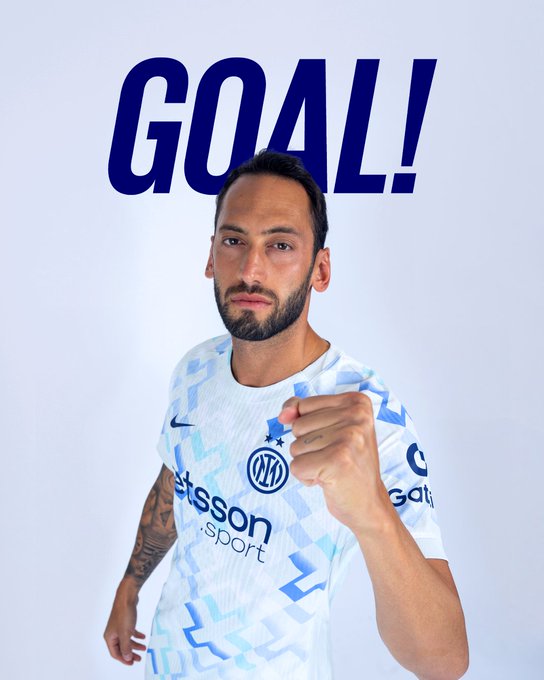 A man with a beard wearing a white patterned soccer jersey with the Inter Milan logo on the chest points forward with his right hand. Bold blue GOAL text is overlaid at the top. The background is plain white.