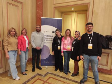 First image shows a large screen displaying Building a B.R.I.G.H.T. Future European Prize 2025 with categories and a globe icon alongside five women seated on a stage in professional attire including hijabs and colorful outfits with eTwinning and European Schoolnet logos visible. Second image displays a screen listing winners from countries like Czech Republic Estonia Greece Portugal Spain and Turkey with names such as Maria Ondrejovska and Galina Dudek grouped by age categories 6-10 and 11-15 years while a diverse group of about 15 people including men and women hold yellow sashes and awards on a red carpet stage with eTwinning Community of Schools in Europe banner. Third image captures six people standing in an ornate room with wooden floors and columns including women in blouses and men in shirts posing in front of a blue eTwinning banner for schools in Europe with lanyards and name tags. Fourth image shows five people standing in a luxurious room with curtains and a banner reading eTwinning the community for schools in Europe featuring individuals in casual professional clothing like striped shirts and jeans with arms crossed and lanyards.
