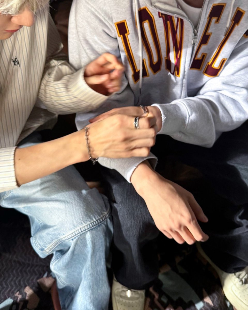 I was completely absorbed in a quiet,  hands-on moment, threading  a  chain  through a pendant and helping jaemin with bracelet, really calming about  focusing  on  something  detailed. I  wore a light striped button-up  shirt  that  day, paired with washed-out denim jeans.