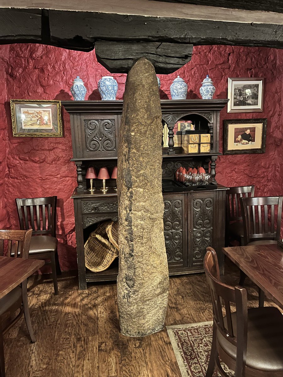 Within the Oxenham Arms in the village of South Zeal, Devon is 
The ‘Roman Pillar' propping up the roof in the restaurant at the rear of the pub.
In the next room is an enormous Menhir built into the fabric of the wall too. One pub - two standing stones.