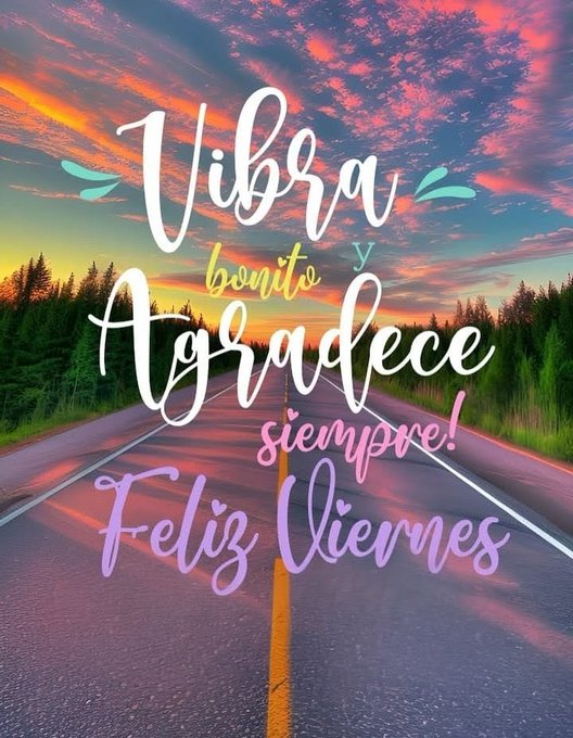 A straight paved road extends into the distance flanked by green pine trees under a dramatic sunset sky with orange pink and purple hues scattered clouds and a glowing horizon. Multicolored handwritten-style text overlays the scene reading Vibra bonito y agradecede siempre in white blue and pink with Feliz Viernes in purple below emphasizing a positive Friday message.