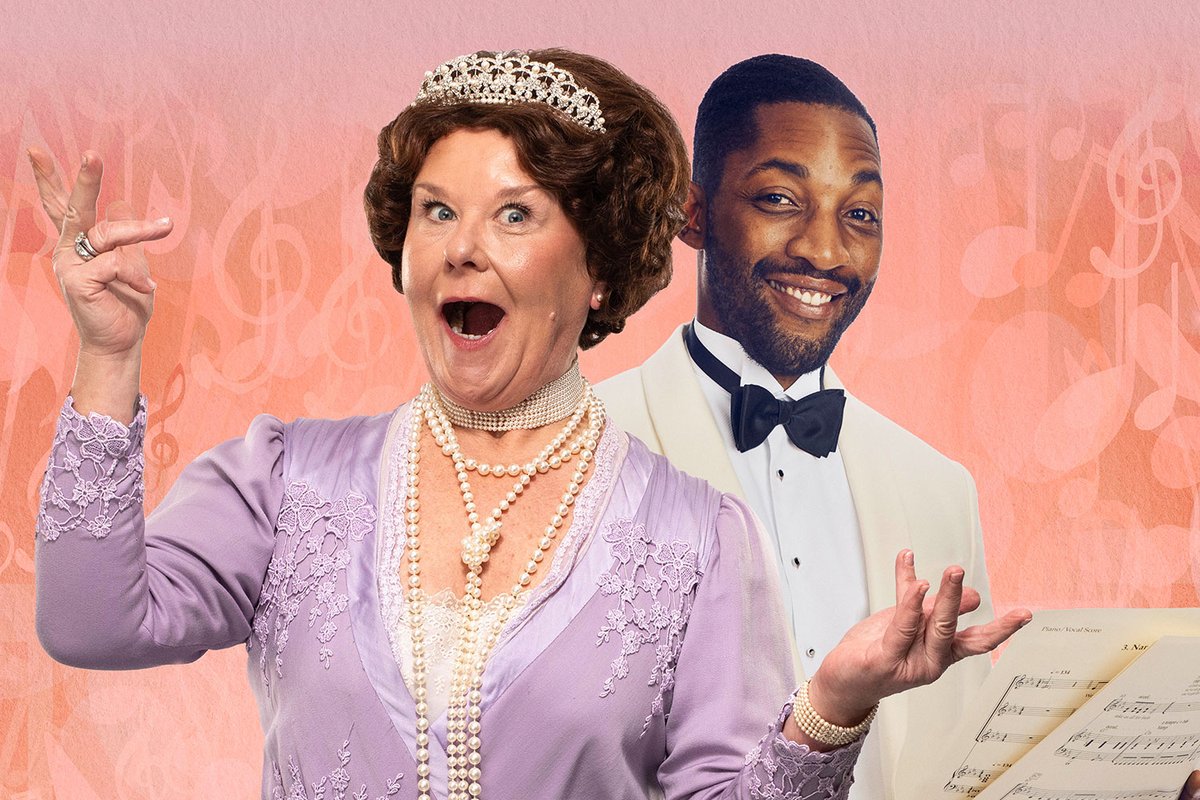 A photo showing two individuals in vintage outfits laughing together in front of a fun pink background