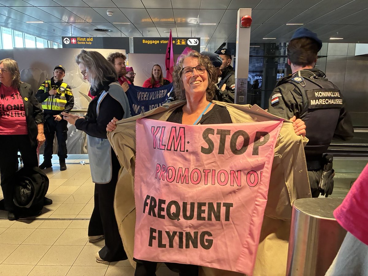 NLRebellion's tweet photo. We zijn terug bij #KLM op #Schiphol. Rebellen van onze fuchsia-elite zijn niet te missen. We eisen dat KLM stopt met het belonen van veelvliegen!

Een kleine elite vliegt er dankzij het Flying Blue programma van KLM nog steeds extra schadelijk op los. 

#stopflyingblue https://t.co/2zncoIIbkn