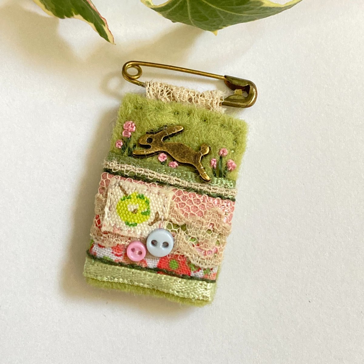 Mini hare themed safety pin brooch in spring green, hand sewn with fabric, trims, vintage lace and tiny buttons on a felt background. A darling little accessory to add charm to outfits and jackets.
elliestreasures.square.site/product/hare-s…

#shopindie #ChristmasGiftIdeas #NatureLovers